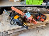 two chainsaws sitting on top of a piece of wood