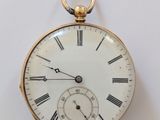 une montre de poche en or avec des chiffres romains sur le cadran