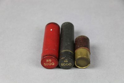 trois douilles rouges et noires posées sur une surface blanche