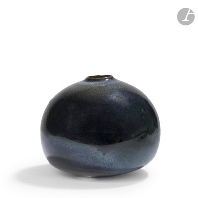 a black vase that is sitting on a white surface