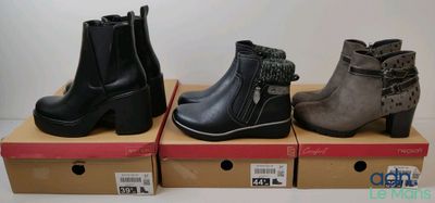 Trois paires de bottines pour femmes sont exposées dans des boîtes