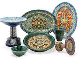 many different colored plates and bowls on a white surface