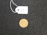 a coin and a price tag on a black surface