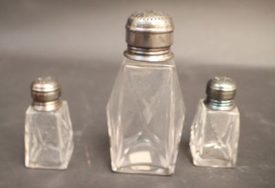 three salt and pepper shakers sitting on a table