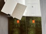 un livre ouvert posé sur une table, à côté d'une pile de papiers