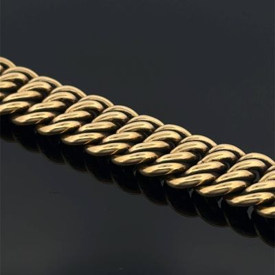 a close up of a gold chain on a black surface