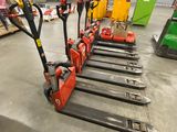 several forklifts are lined up in a warehouse with pallets