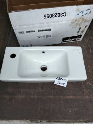 a white sink sitting next to a cardboard box