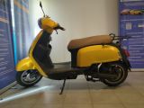a yellow scooter parked in front of a blue wall