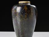 a vase that is sitting on a table with a black background