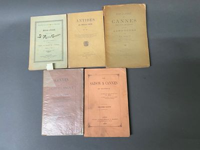 Quatre vieux livres sont posés les uns à côté des autres sur une table