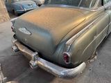 an old car that is parked on the side of the street