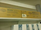 deux boîtes posées sur une étagère dans un magasin, avec un rouleau de papier dessus