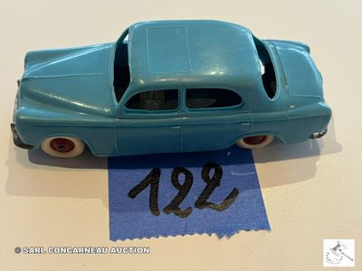 une petite voiture posée sur une feuille de papier bleue