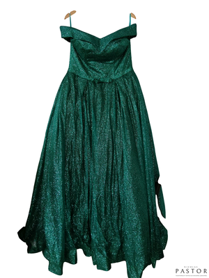 La robe verte est suspendue à un cintre sur un fond blanc.