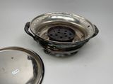 a metal strainer with a metal lid on a table