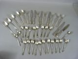 many forks and spoons arranged in a circle on a table