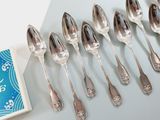 several silver spoons and spoon spoons are lined up on a table