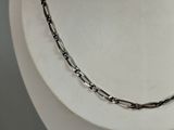 silver chain necklace on a mannequin display on a white surface