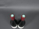 two bottles of wine sitting on a gray surface