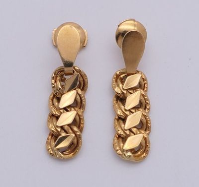 deux paires de boucles d'oreilles en or ornées de feuilles, posées sur un fond blanc