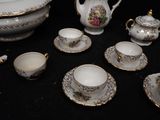 a black table with a bunch of white and gold china