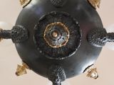 a chandelier that has a black and gold design on it