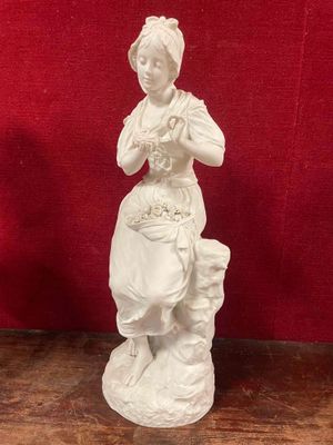 a white statue of a woman with a dog on a table