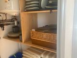 many plates and pans stacked on a shelf in the kitchen
