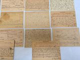 several pieces of old paper with writing on them sitting on a table