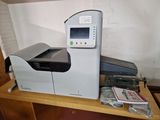 the printer is sitting on a wooden shelf next to a package of cigarettes