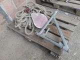 a wooden pallet with rope and a metal object on top of it