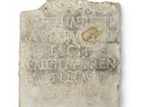l'image d'une pierre portant une inscription, posée sur une surface blanche