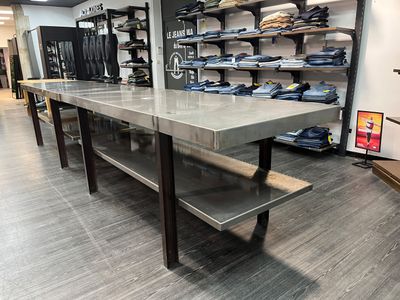 une longue table sur laquelle sont posées plusieurs chemises