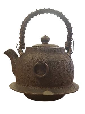 a brown tea pot with a handle on a plate