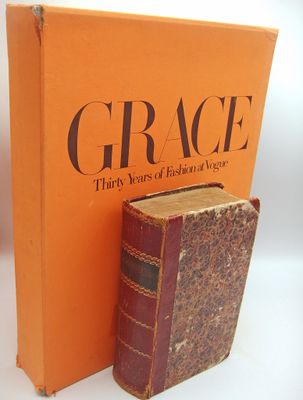 an orange book sitting next to a brown book on top of a white table