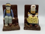 deux figurines d'un homme et d'une femme assis sur un banc