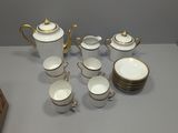 an image of a table topped with a white and gold tea set