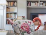 une théière posée sur une table devant une bibliothèque