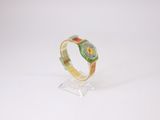 a close up of a ring on a clear stand on a white surface