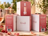 trois cartons de vin rosé posés sur une table, à côté d'un verre de vin