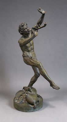 statue en bronze représentant un homme tenant un oiseau sur un rocher