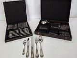 deux services d'argenterie dans un coffret posé sur la table