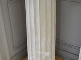 a white pedestal with a clock on top of it