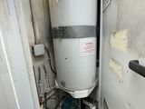 a water heater that is in the corner of a room