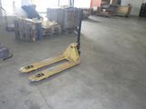 a picture of a forklift in a warehouse with pallets in the foreground