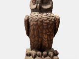 an owl statue sitting on top of a wooden block