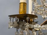 a chandelier with a candle and some crystals hanging from it
