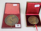 une médaille d'or dans un coffret rouge orné d'un ruban rouge