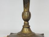 an antique brass table lamp with a glass shade on top